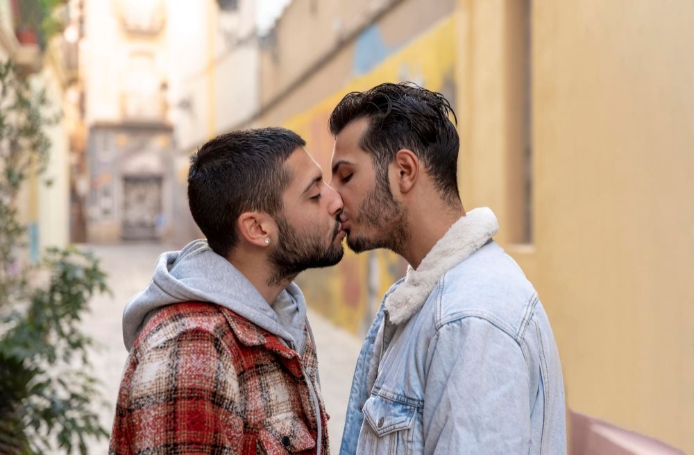 Two gay men kissing outdoors