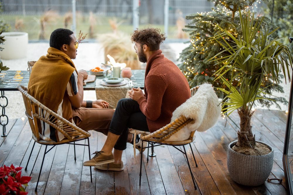 Two adult men talking in a café