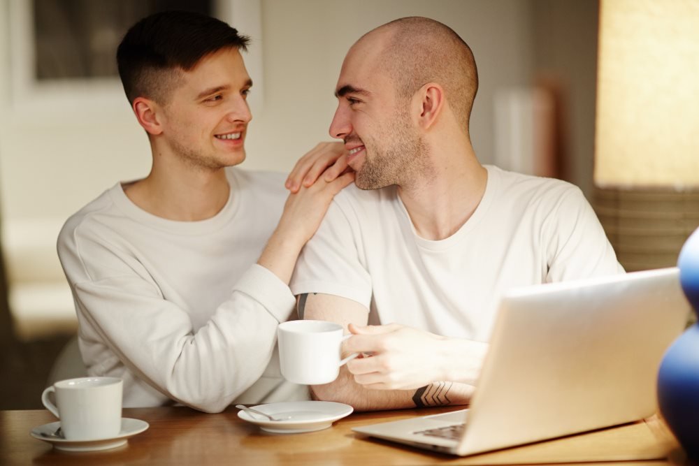 Two adult men sharing coffee at home